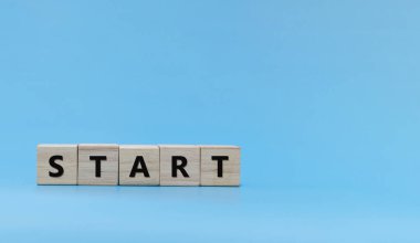 Başla. Sözcük START mavi arkaplan üzerindeki tahta blok yığını, yeni yıl tebrikleri, trend, fikir, finans, strateji, iş kurma, çevrimiçi pazarlama, hedef ve hedef konsepti üzerine yazıldı