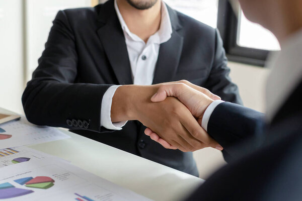 Deal. business people handshake after business signing contract document on desk in meeting room at company office, partnership, job interview, investor, negotiation, partnership and teamwork concept