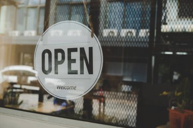 We Are Open, coffee cafe shop text on vintage sign board hanging on glass door in cafe shop reopen after coronavirus quarantine is over in restaurant ready to service, small business owner concept
