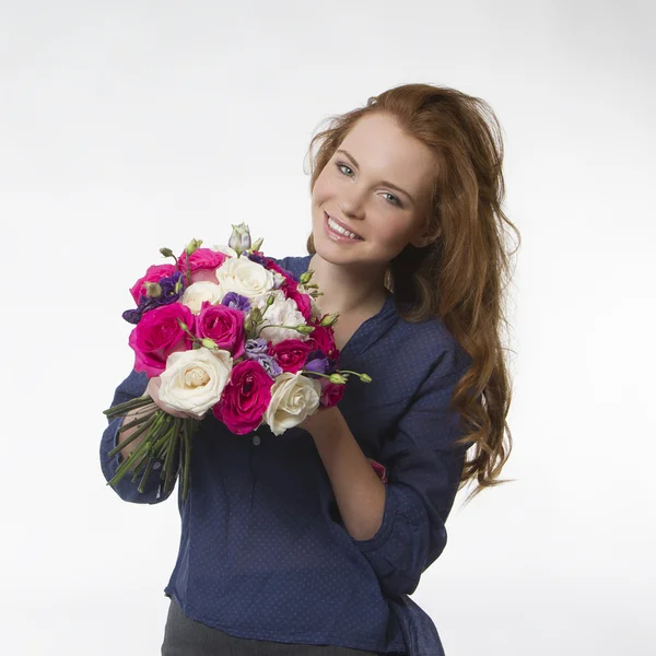 Beautiful smiling girl with a bouquet of flowers on a white background — Stock Photo, Image