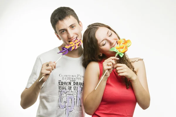 Happy young couple with colorful lollipops on white background — Stock Photo, Image