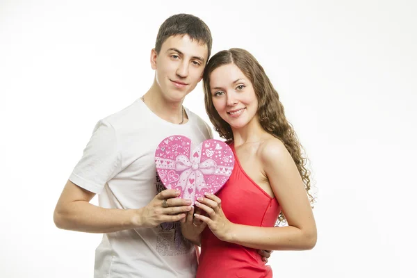 Mooie jonge liefde paar op een witte achtergrond met een cadeau — Stockfoto