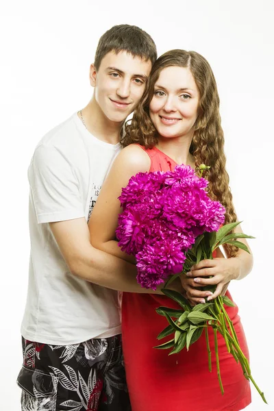 Beautiful young love couple on a white background with a bouquet of flowers — Stock Photo, Image