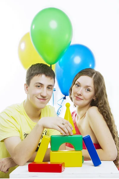Gelukkige jonge paar spelen met speelgoed op witte achtergrond Stockfoto