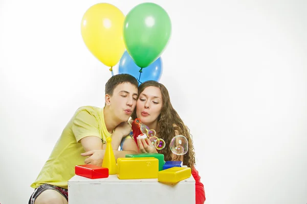 Feliz jovem casal jogar com brinquedos no fundo branco Fotos De Bancos De Imagens