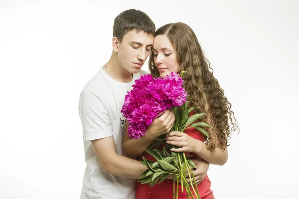 Bella giovane coppia d'amore su uno sfondo bianco con un mazzo di fiori Foto Stock