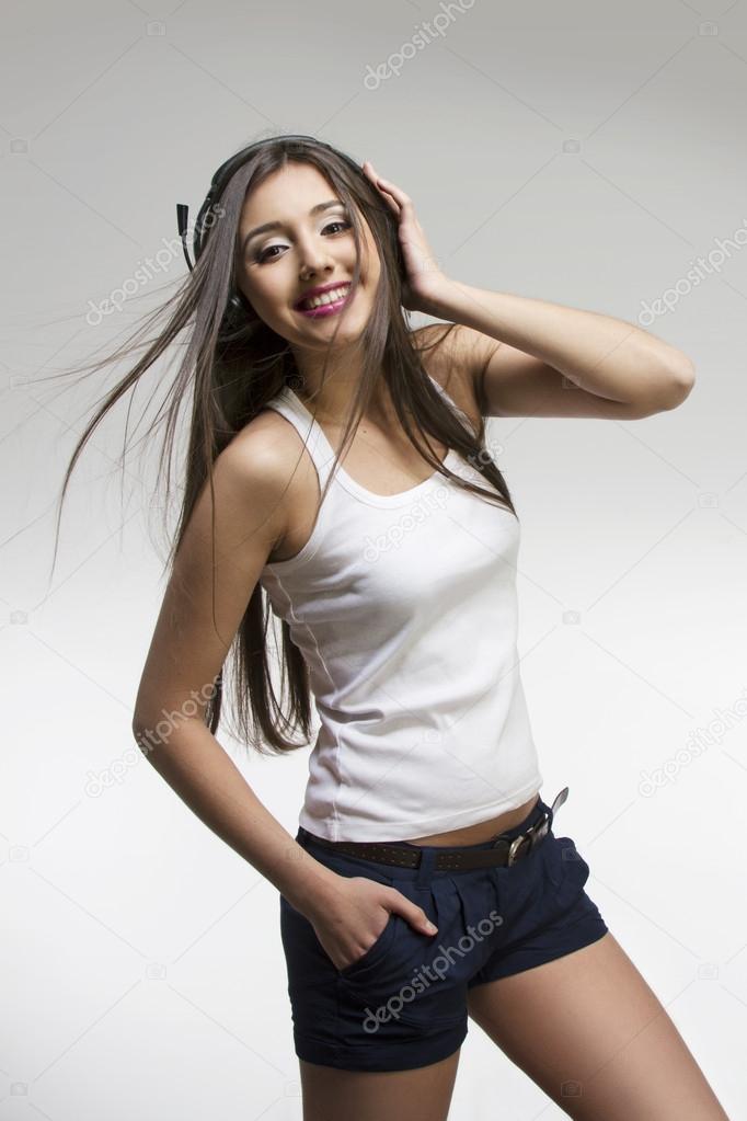 Portrait of a young smiling girl with headphones listening to music