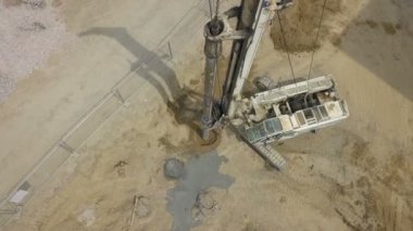 Aerial view of a heavy construction equipment digging holes on a construction site