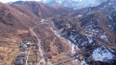 Uzakta yüksek karlı zirveler duruyor. Drone görünümü