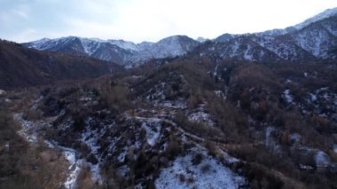 Uzakta yüksek karlı zirveler duruyor. Drone görünümü