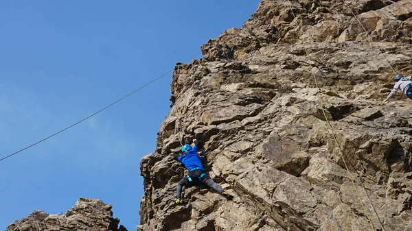 Ein Mann hoch oben auf einer Klippe versucht, sich einen Vorsprung zu schnappen — Stockfoto