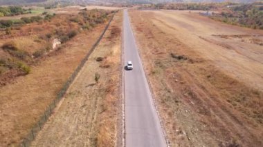 A white jeep is driving on the road.