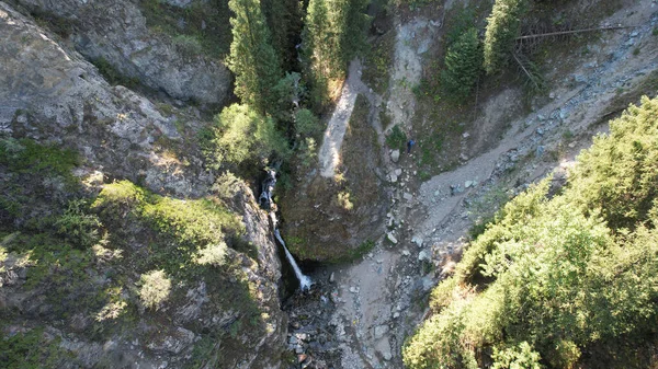 Гірський водоспад в скелястій ущелині з лісом — стокове фото