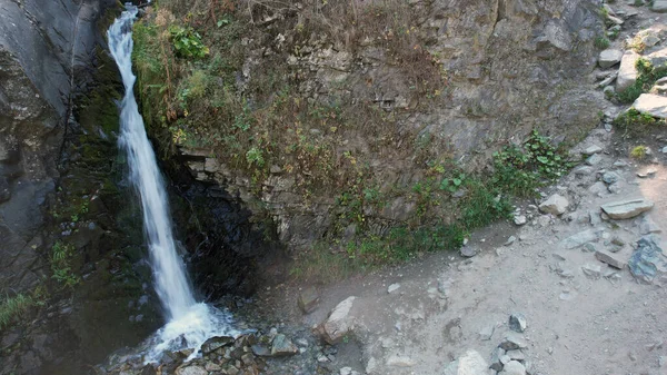 Ein Gebirgswasserfall in einer felsigen Schlucht mit Wald — Stockfoto