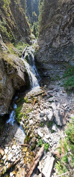 Una cascada de montaña en un barranco rocoso. — Foto de Stock