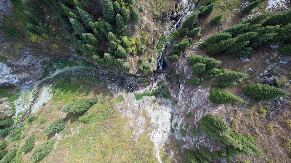 Uma cachoeira de montanha em um desfiladeiro rochoso. — Fotografia de Stock