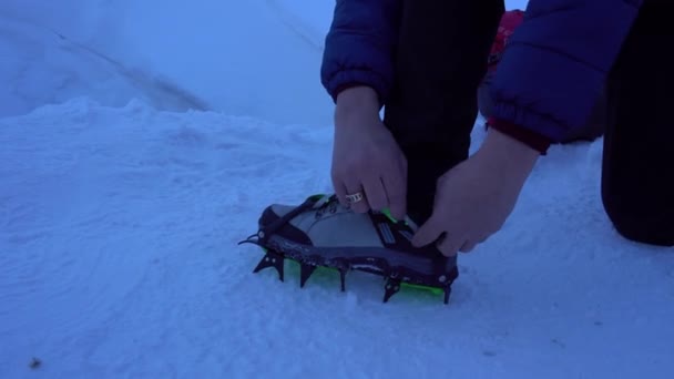 El tipo pone espigas en las botas de montaña. — Vídeo de stock