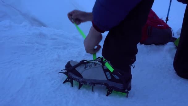 Il tipo mette delle punte sugli scarponi da montagna.. — Video Stock