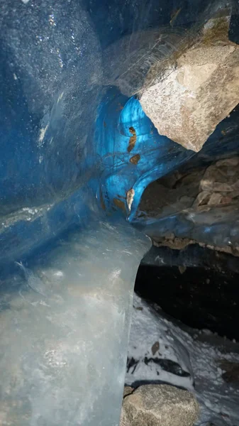There are rocks and ice inside the ice cave. — стоковое фото
