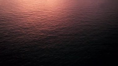 Deniz ve ada manzaralı turuncu gün batımı