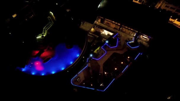 Uitzicht op de nacht stad met verlichting en een zwembad — Stockvideo