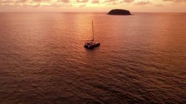 Gün batımında ada manzaralı lüks bir yat..