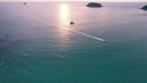 Parasailing ao pôr-do-sol com vista para a ilha. — Vídeo de Stock
