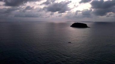 Bulutlarla, denizle ve adayla güzel gün batımı.