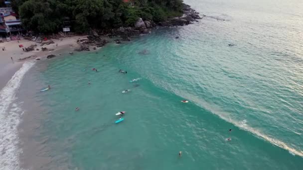 Surfer fangen Wellen bei Sonnenuntergang. Der Blick von der Drohne — Stockvideo