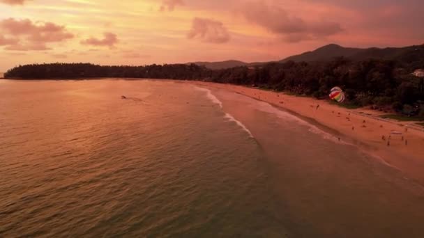 Parasailing vid en orange solnedgång på stranden. — Stockvideo