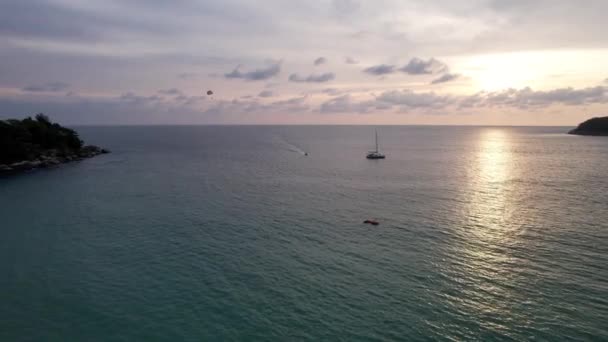 Parasailing at sunset with a view of the island. — Stock Video