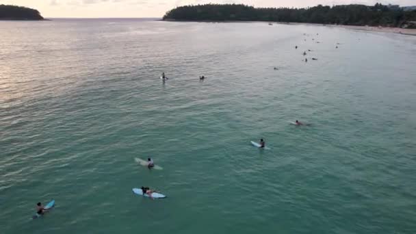Los surfistas cogen olas al atardecer. La vista desde el dron — Vídeos de Stock