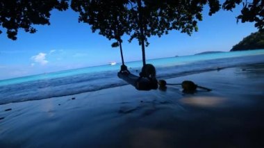 Okyanus manzaralı ve tekneli sahilde sallan..