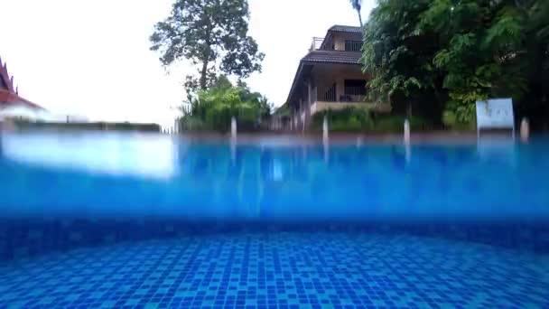 Raindrops fall on the water in the pool. — Vídeo de stock