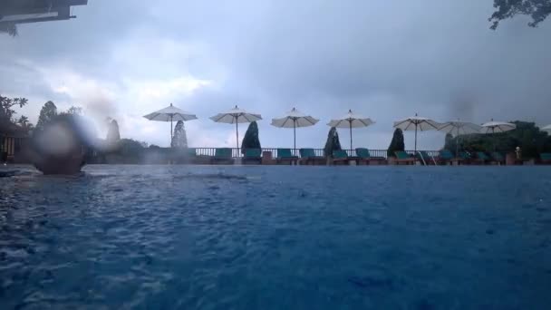 Raindrops fall on the water in the pool. — Stock videók