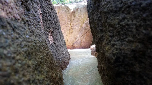 Um corredor de pedras na praia. Fluxos de água. — Fotografia de Stock
