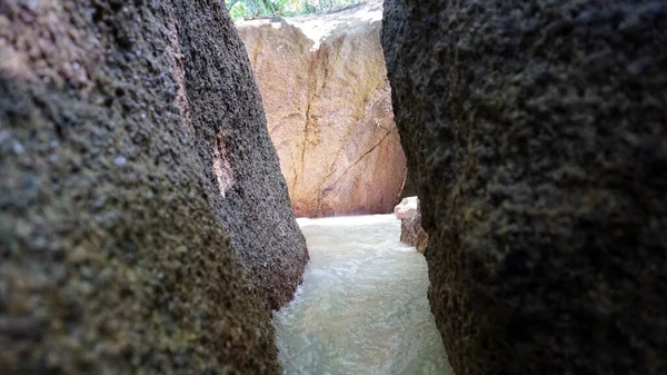 A corridor of stones on the beach. Water flows.