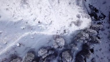 A broken gazebo stands on snowy hill in mountains