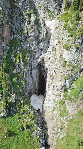 Bovenaanzicht op steile bergkliffen en een ijsgrot. — Stockfoto