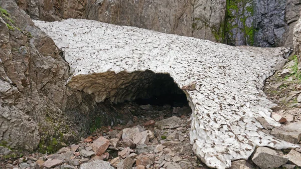 Grotta di ghiaccio, una grotta di neve in montagna in estate — Foto Stock