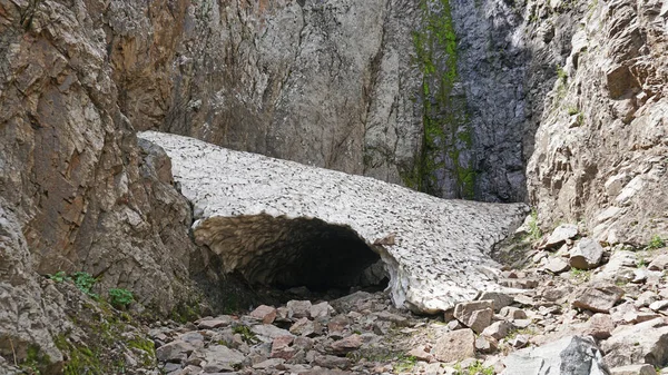 Gruta de gelo, uma caverna de neve nas montanhas no verão — Fotografia de Stock