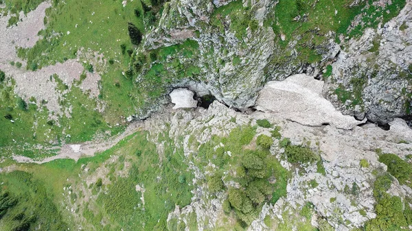 Blick von oben auf steile Bergklippen und eine Eishöhle. — Stockfoto