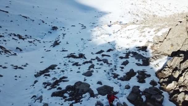 Turisté kráčejí po sněhové stezce v horách. — Stock video