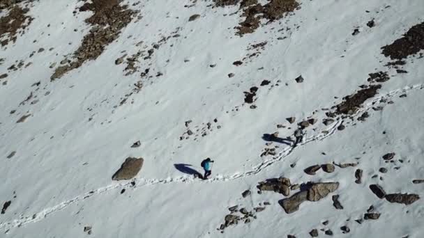 Turiștii merg pe un traseu de zăpadă în munți . — Videoclip de stoc