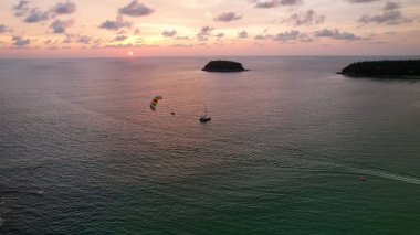 Sahilde turuncu bir günbatımında parasailing..