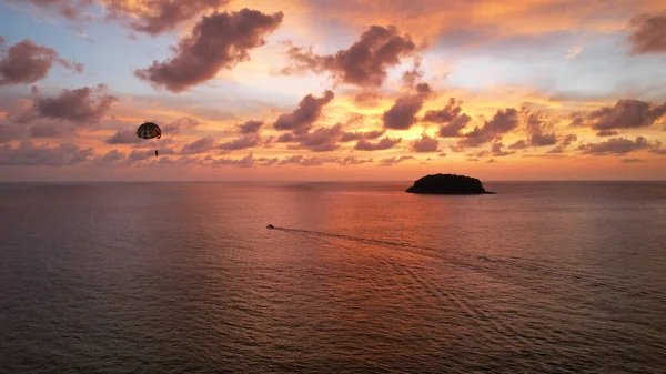 Parasailing at an orange sunset on the beach. — стоковое фото