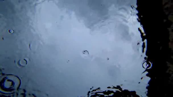 Zicht van onder het water naar de lucht en regen — Stockvideo