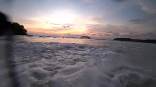 Uma onda cobre a câmara. Pôr do sol no mar. — Vídeo de Stock