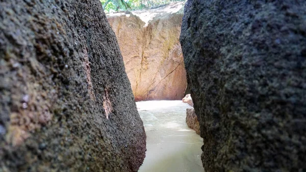 A corridor of stones on the beach. Water flows. — Foto de Stock