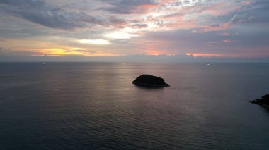 Kırmızı-turuncu gün batımı bulutlarla yansıtılır..